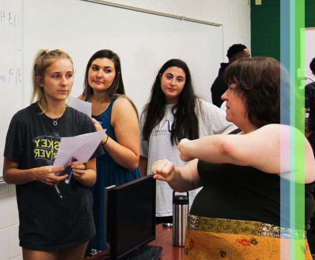 Mathematics professor explaining a math problem to students at the board.