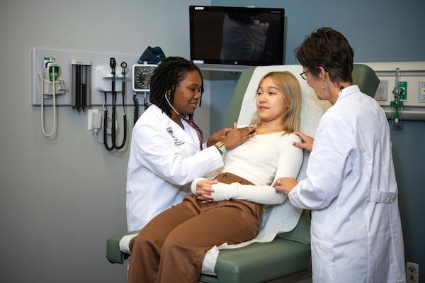 Two nursing students with a patient.